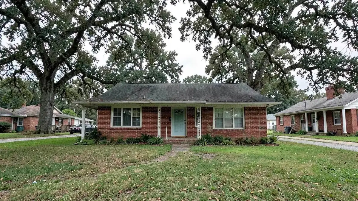 Brick ranch house with mature oak trees on a residential street in Tupelo, Mississippi